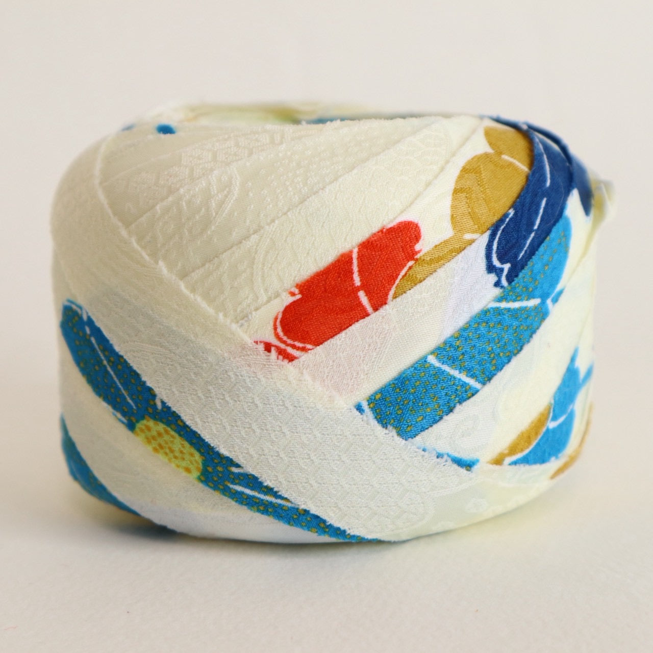 薄い卵色に赤・緑・青・黄の花柄・化繊(Y02601004）