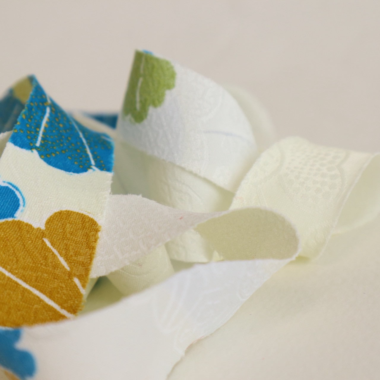 薄い卵色に赤・緑・青・黄の花柄・化繊(Y02601004）