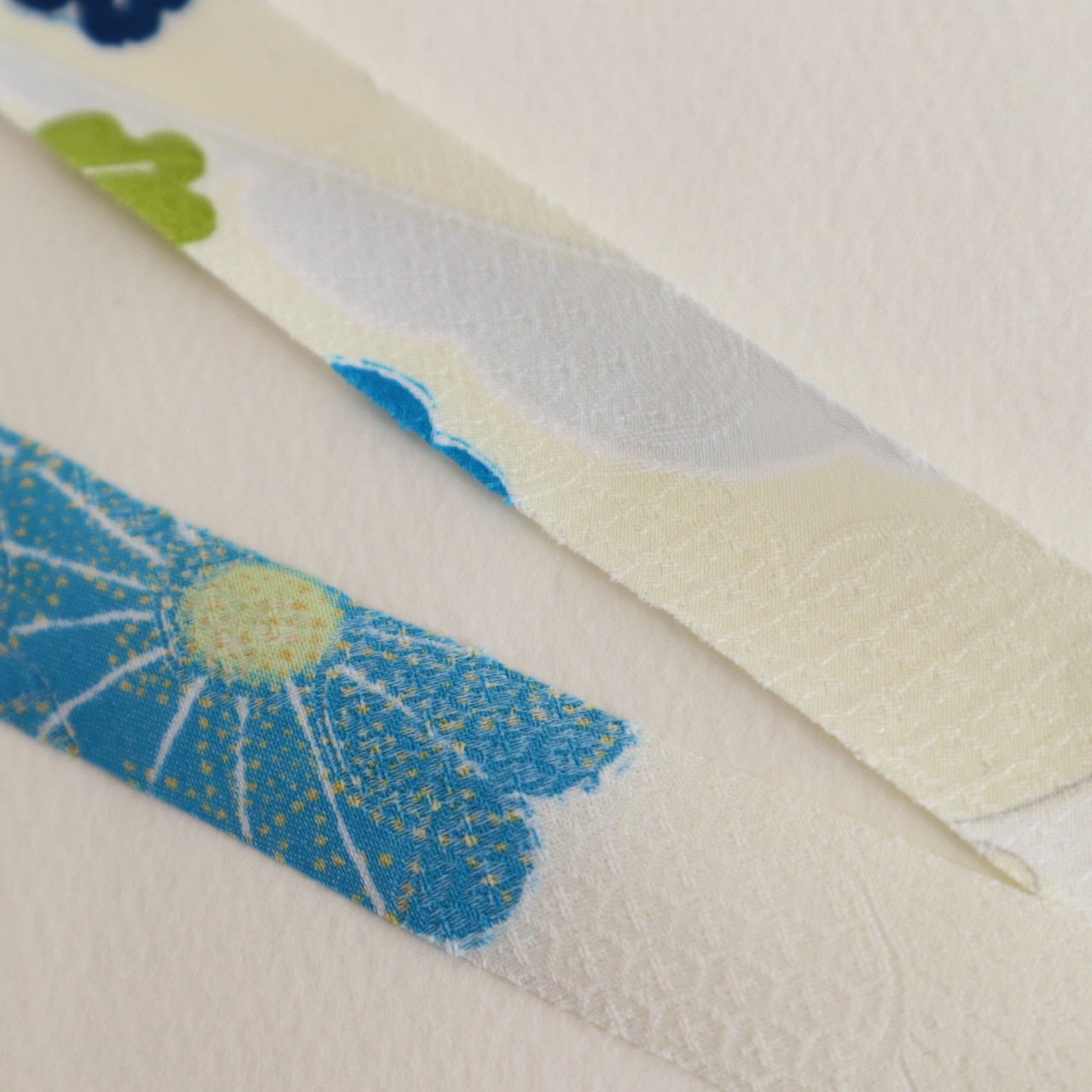 薄い卵色に赤・緑・青・黄の花柄・化繊(Y02601004）